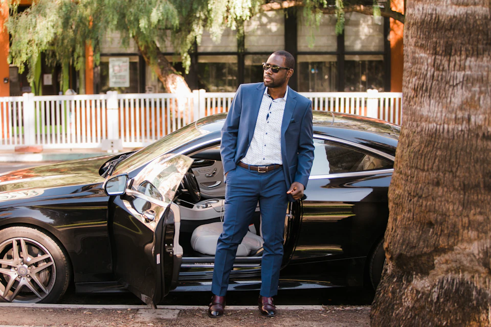 A professional driver standing beside his car, the kind of private driver travellers hire for day trips from Marrakech