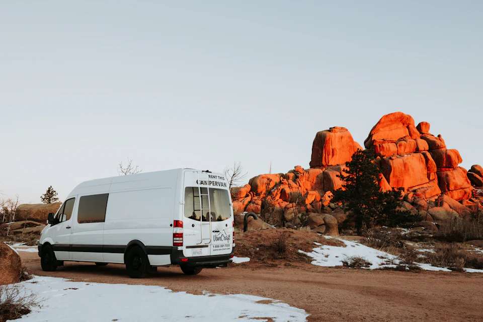 White minibus parked on a desert road in Morocco, the type of vehicle used for group transfers of 7 to 14 passengers
