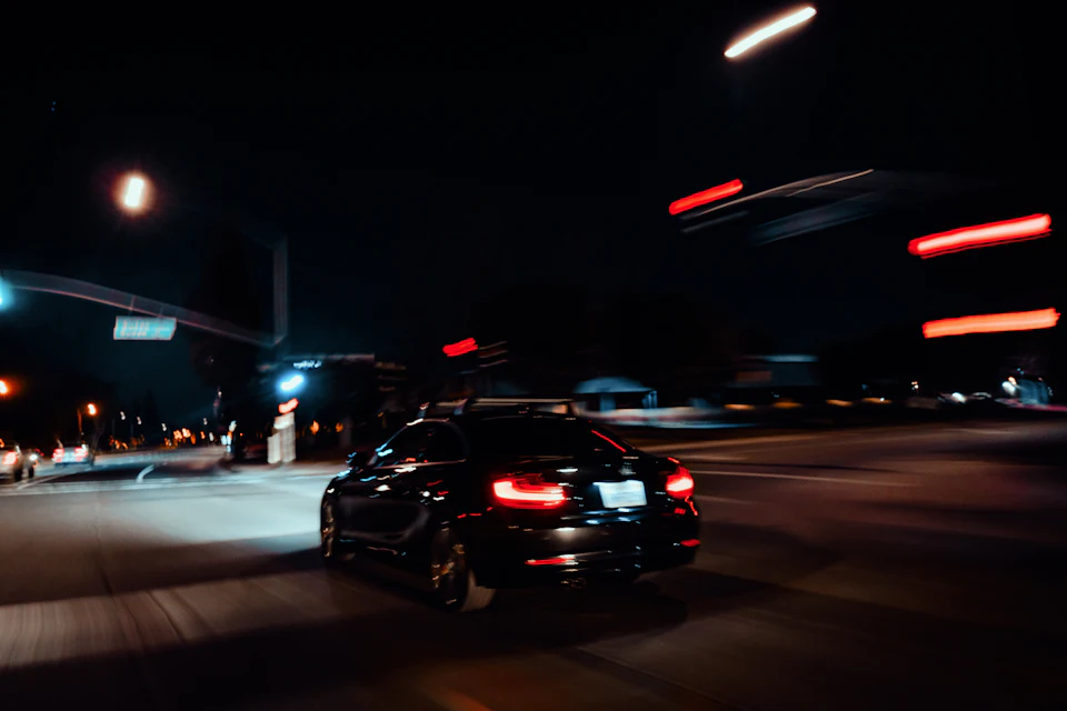 Car driving through city lights at night, the hour when Marrakech airport taxi prices are highest.