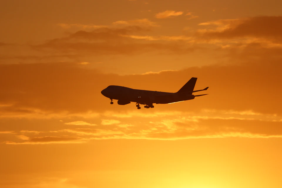 Aircraft silhouette against a sunset sky, the kind of evening approach that brings late flights into Marrakech Menara Airport.