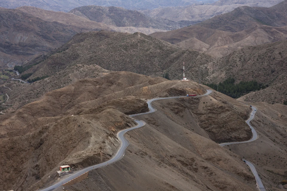 Empty desert road leading towards the mountains, the kind of stretch a one-way Morocco itinerary crosses between Marrakech and Fes